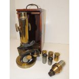 A brass Ross Eclipse monocular microscope, with objectives, in polished wood case (lacks door)