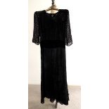 A c.1940's evening dress in black devore velvet and black silk lining, with rounded neck and wide