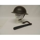 A WWII period green painted metal helmet with original liner and webbing chin strap together with