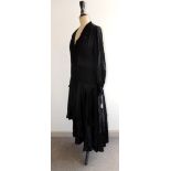 A c.1920's black silk dress having "V" neck, long sleeves with buttoned cuffs, dropped waist and