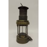 A Gremlin brass miners lamp, 22cms high ++glass cracked, burner missing and two of the brass