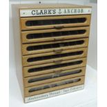 A shop cabinet for Clarke's Anchor Embroidery Thread, the light wood cabinet with seven narrow glass