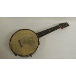 A Banjolele having four strings and decorative back with engraved foliate decoration, 56cms long