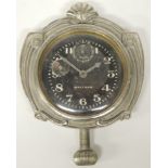 A Waltham dashboard 8 day timepiece in decorative white metal surround and having black dial with