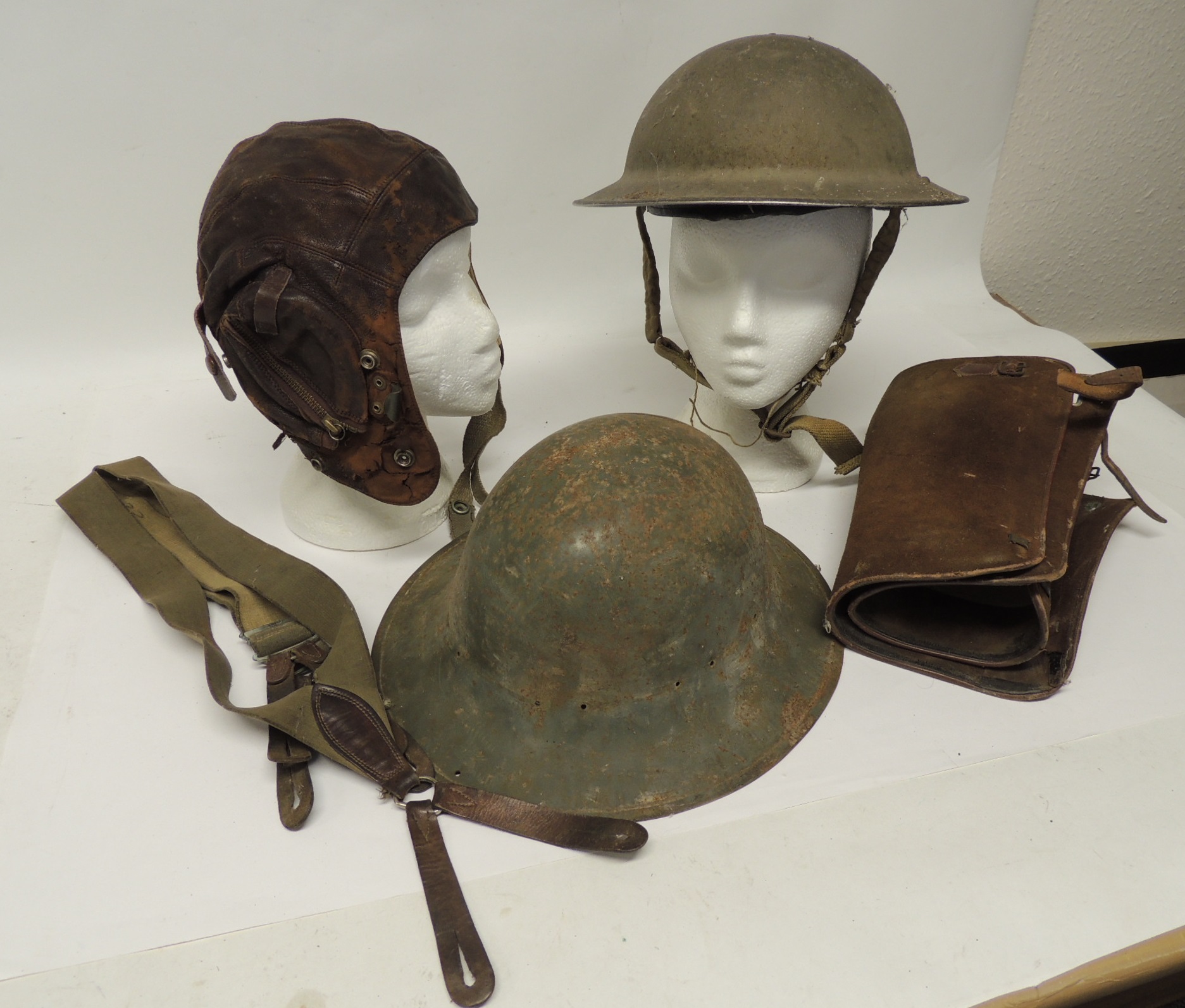 A brown leather flying helmet with chamois leather lining and webbing chin strap; a WWII metal