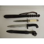 A 20th Century bayonet with black grip, deeply fullered blade and black metal scabbard, blade