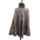 A Victorian black cape trimmed with black silk rosettes to the collar, black silk embroidery and
