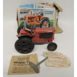 A Triang Minic clockwork Nuffield Tractor with driver, key and "Smoke-Puff" envelope all in original