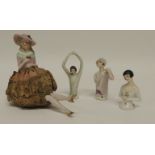 An early 20th Century German porcelain half doll pin cushion with attached legs together with