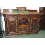 A Victorian carved oak sideboard with low raised back, three frieze drawers, central open shelf