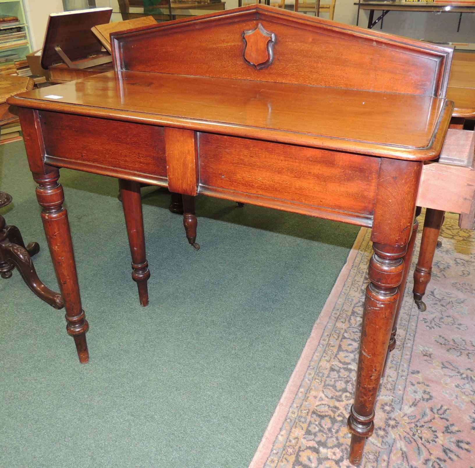 A Victorian mahogany hall table with low arched raised back, fitted with single side frieze drawer