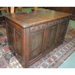 An early 20th century oak coffer bach, having carved frieze and panelled front and sides, 55cm high,