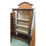An early 20th century display cabinet, having inlaid raised back, leaded glass door enclosing two