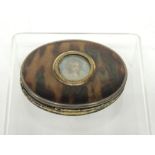 A 19th Century oval tortoiseshell, horn and silver snuff box the top with inset miniature portrait