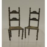 A pair of 19th Century Dutch hand made silver miniature ladder back chairs with turned supports