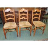 A set of three late 19th century/early 20th century ladder back rush seated chairs.