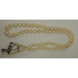 A single strand of freshwater pearls with white metal clasp set with three small diamonds.