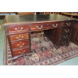 A mahogany pedestal desk with inset leather top gadroon edging, central drawer and pedestals with