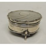 A circular silver trinket box, the hinged cover with lined detail and with shaped edge, velvet lined