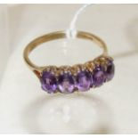 A 9ct gold dress ring, set with five oval faceted mauve glass stones, size R.