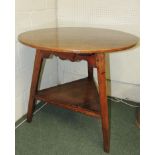 A George III oak cricket table having circular top, shaped frieze, triangular lower platform and