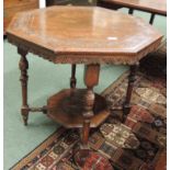 A late Victorian carved oak octagonal centre table with turned supports and octagonal lower shelf,