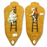 A pair of Naples Capodimonte porcelain figures of girl and boy climbing ladders, on velveteen