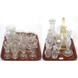 Two trays of cut glass including decanters, drinking glasses, candlestick, sundae dishes etc