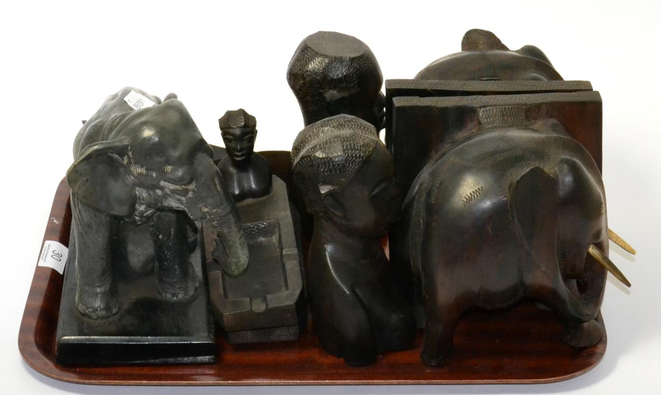 A tray of carved ebony figures, bookends, ashtrays etc