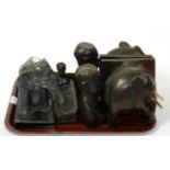 A tray of carved ebony figures, bookends, ashtrays etc