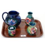 Four pieces of Walter Moorcroft pottery, including Anenome pattern jug and vase and Hibiscus pattern