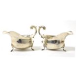 A pair of silver sauce boats with c scroll handles and each raised on three feet10.3 ozt