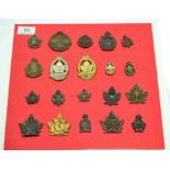 A Collection of Twenty First World War Canadian Cap and Collar Badges, in bronze, brass and white