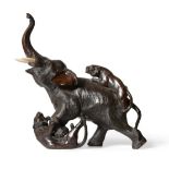A Japanese Bronze Okimono, Meiji period, as an elephant being attacked by two tigers, ivory tusks,