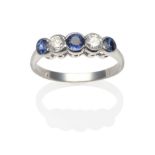 A Sapphire and Diamond Five Stone Ring, three graduated round cut sapphires spaced by round