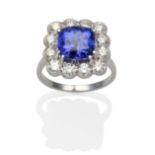 A Tanzanite and Diamond Cluster Ring, a cushion cut tanzanite in a white claw setting within a
