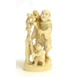 A Japanese Ivory Okimono of a Street Entertainer, Meiji period, standing, a monkey on his