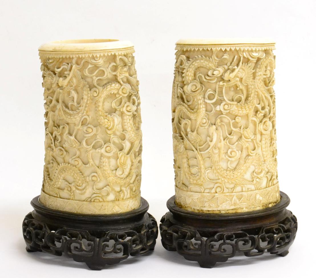 A Pair of Chinese Ivory Tusk Vases, mid 19th century, carved with dragons above a pagoda, on