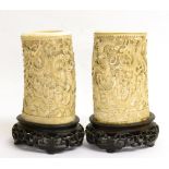 A Pair of Chinese Ivory Tusk Vases, mid 19th century, carved with dragons above a pagoda, on