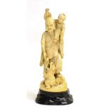 A Japanese Ivory Okimono of a Man, Meiji period, standing wearing traditional costume, his son on