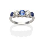 A Sapphire and Diamond Five Stone Ring, three graduated round cut sapphires spaced by round