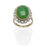 A Jade and Diamond Cluster Ring, an oval cabochon jade in a yellow rubbed over setting, within a