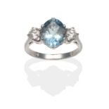 An Aquamarine and Diamond Three Stone Ring, an oval cut aquamarine between two round brilliant cut
