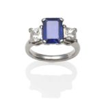 A Sapphire and Diamond Ring, an emerald-cut sapphire flanked each side by a princess cut diamond