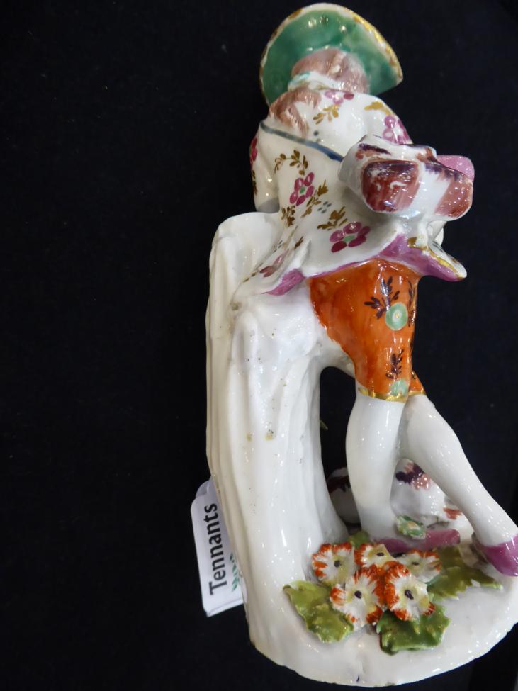 A Bow Porcelain Figure of a Shepherd, circa 1765, leaning against a tree trunk playing pipes, his - Image 4 of 4