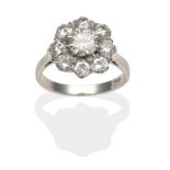 A Diamond Cluster Ring, a round brilliant cut diamond in a white claw setting within a border of