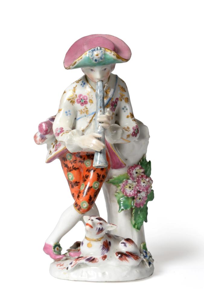 A Bow Porcelain Figure of a Shepherd, circa 1765, leaning against a tree trunk playing pipes, his