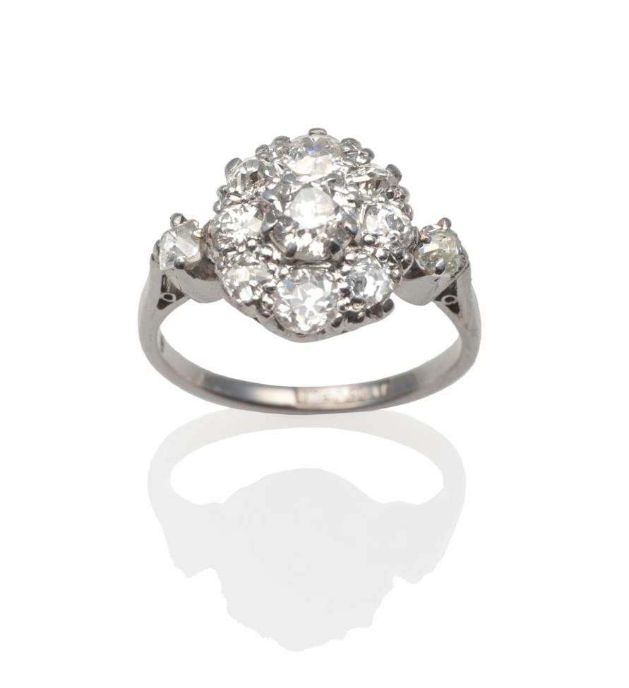 A Diamond Cluster Ring, an old cut diamond within a border of smaller old cut diamonds in white claw