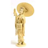 A Japanese Ivory Okimono, Meiji period, as a girl wearing traditional dress holding a parasol and