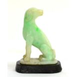 A Chinese Green Jadeite Figure of a Hound, 19th century, seated looking back on an oval base, 7cm